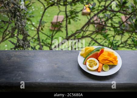 colorful fruit plate on the balcony overlooking the garden Stock Photo