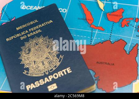 Top view of Brazilian passport over map. Focus on the continent Oceania. Emigration, travel, destination concept. Stock Photo