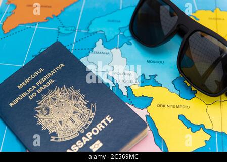 Top view of Brazilian passport over map. Focus on the European continent and the Middle East. Emigration, travel, destination concept. Stock Photo