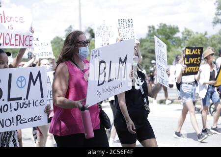 People march and hold up posters along the streets to fight against racism and support Black Lives Matter Stock Photo