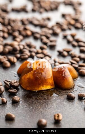 Frozen coffee shaped like heart. Coffee ice cubes and coffee beans. Stock Photo