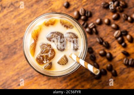 Iced coffee with coffee ice cubes on wooden table. Top view. Stock Photo