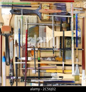 A lay flat arrangement of used real artists painting brushes. Arranged in a square composition. Multiple brushes of varying sizes organized in a table Stock Photo