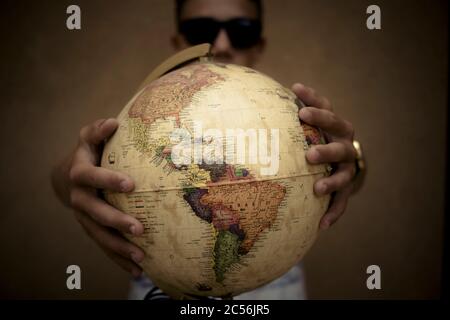 Concept of world globe and people protecting or holding it - save planet earth from danger - planning trip or holiday vacation for wanderlust caucasia Stock Photo