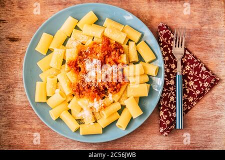 Above view of beautiful tasty pasta food with tomatoes ragu and parmigiano cheese - concept of italian food restaurant or home kitchen - single life i Stock Photo