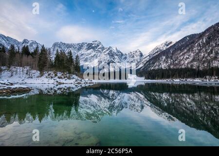 The upper lake of Fusine with mount Mangart on the background in winter. Fusine Lakes Natural Park, Fusine di Valromana, Tarvisio, Udine province, Fri Stock Photo