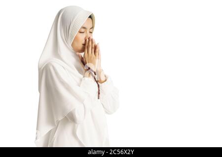 Muslim young woman praying open her arm isolated over white background Stock Photo