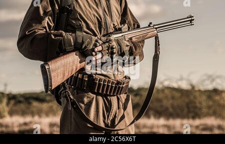 Hunter man. Hunting period, autumn season. Male with a gun. A hunter with a hunting gun and hunting form to hunt in an autumn forest. The man is on Stock Photo