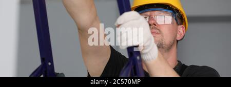 Builder holds metal equipment and looks at ceiling Stock Photo