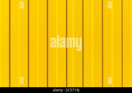 Tin fence with a beautiful textured pattern. Modern fence with vertical stripes. Stock Photo