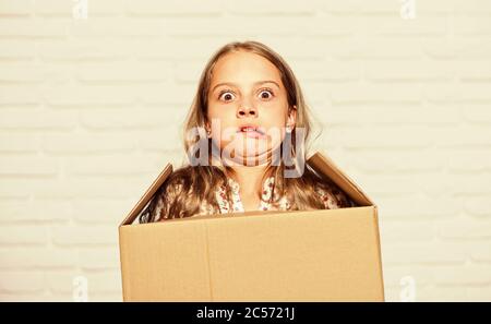 Make moving easier. Girl small child carry cardboard box. Move out concept. Prepare for moving. Rent house. Real estate. Delivering your purchase. Kid moving out. Moving routine. Packaging things. Stock Photo