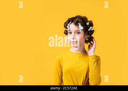 pose with tin foil hair curlers. happy girl in hair curlers playing hairdresser salon. Easy tips making hairstyle for kids. hairdressing tools and hair accessories. kid with happy face. copy space. Stock Photo