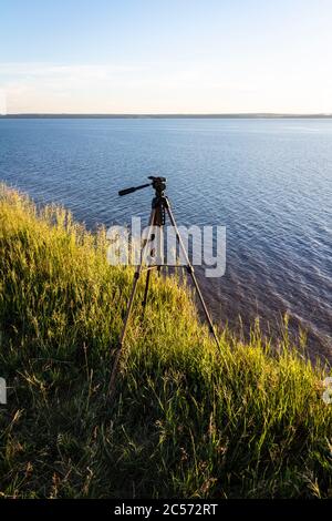 The tripod is ready to work and is mounted on top of a mountain with sea views. Stock Photo