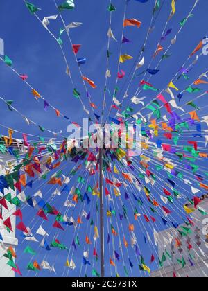 Vibrant multicolored flags against sunny blue sky Stock Photo