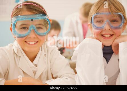 Portrait smiling junior high school girl students in science goggles Stock Photo