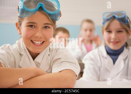 Portrait happy junior high school students in science goggles Stock Photo