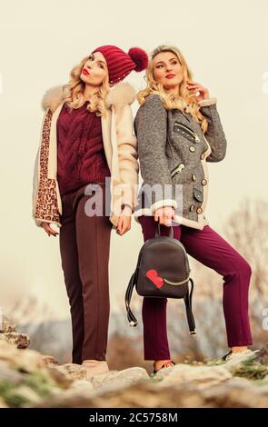 Stay warm and fashionable. Women wear furry coats. Winter clothes. Wardrobe  for cold weather. Girls enjoy cozy fancy chic coats. Natural wool sheepskin  coats. Fur shop. Backpack fashion accessory Stock Photo 