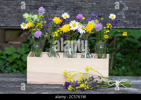 bouquet of meadow flowers in glass bottles as rustic decoration Stock Photo