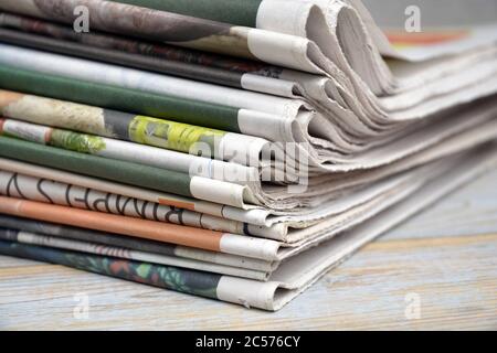 Selective focus shot of the stack of newspapers isolated on a wooden surface Stock Photo