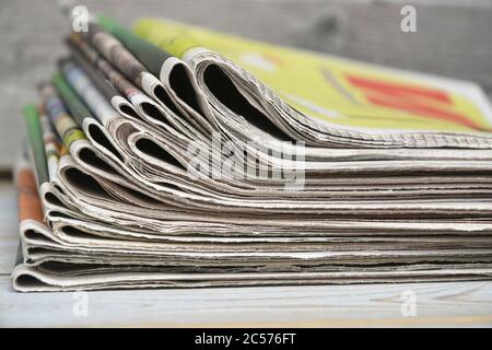 Selective focus shot of the stack of newspapers isolated on a wooden surface Stock Photo