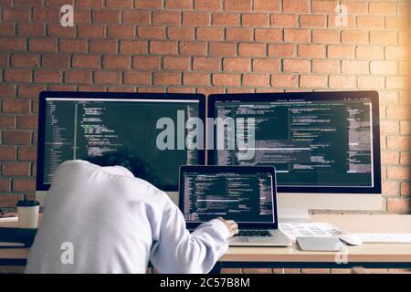Man programmers are sleeping while working analyzing on desk in code at office room. Stock Photo