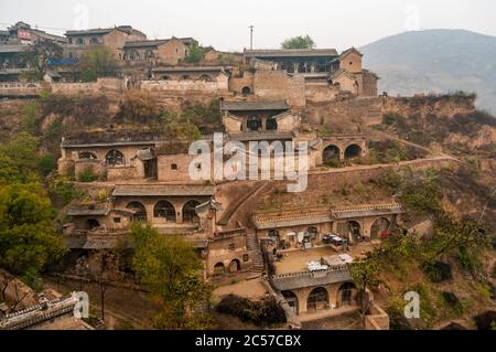 Stone entrances to cave dwellings line the terraced hillside in Lijiashan Village, Shanxi Province, China Stock Photo