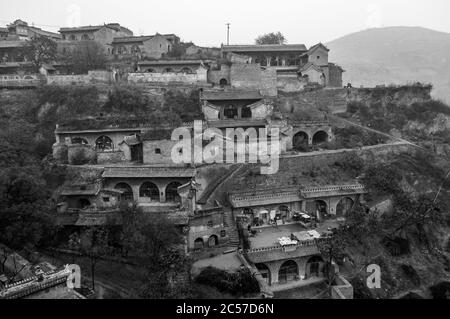 Stone entrances to cave dwellings line the terraced hillside in Lijiashan Village, Shanxi Province, China Stock Photo