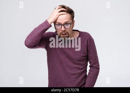 man in terror and shock, holding head, shocked by the quantity his of problems. Stock Photo