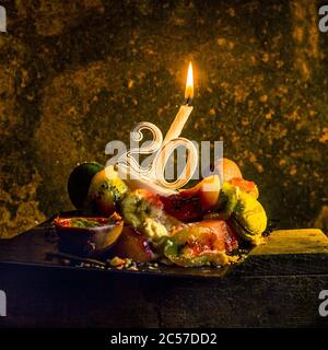 Dessert with fruits with a candle for the twentieth birthday Stock Photo
