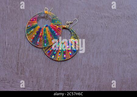 Rainbow color ear ring with beautiful design on a wooden surface Stock Photo