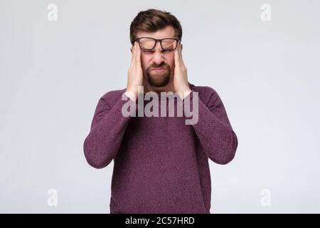 Man having headache pressing on his temples. Stock Photo