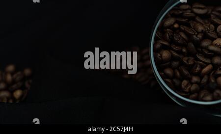 Fragrant, grain coffee in a beautiful transparent container on black background Stock Photo
