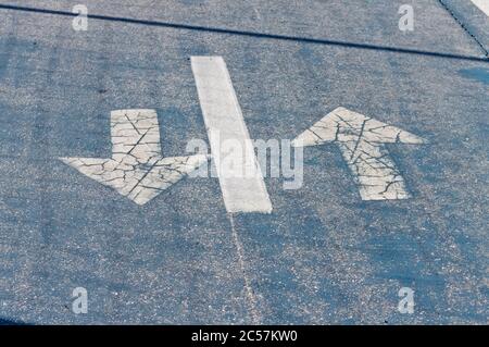 Horizontal signage of a blue cycle path with white directional arrows (Pesaro, Italy, Europe) Stock Photo