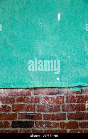 Green painted concrete wall and brown brick wall texture background Stock Photo