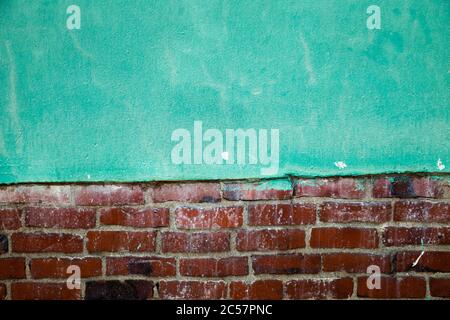 Green painted concrete wall and brown brick wall texture background Stock Photo