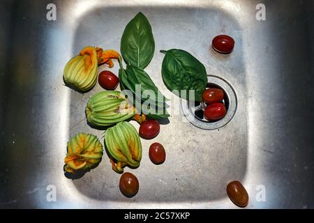 top view of cherry tomatoes, basil leaves and courgette flowers Stock Photo