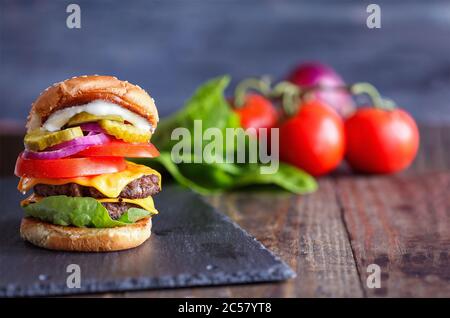 A big, fat, juicy double cheeseburger made with two 100% beef patties, slices of melted cheese, onions, pickles, lettuce, tomatoes, and mayo on a fres Stock Photo