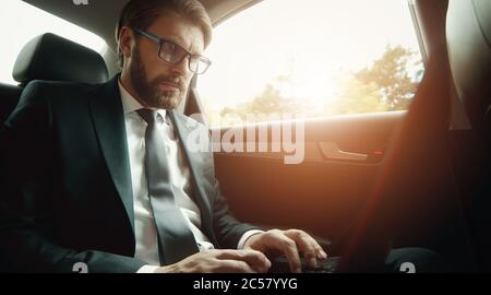 Businessman using laptop traveling car Stock Photo