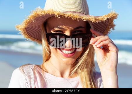 Woman wearing hat and sunglasses smiling Stock Photo