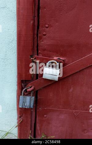 Two gray locks on a burgundy door. Perfect protection. Stock Photo