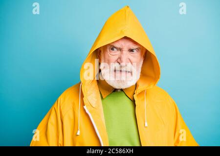 Close-up portrait of his he dissatisfied evil irritated annoyed grey-haired man wearing yellow overcoat bad rainy weather isolated over bright vivid Stock Photo