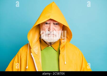 Close-up portrait of his he gloomy dissatisfied grey-haired man wearing yellow topcoat dislike bad weather isolated over bright vivid shine vibrant Stock Photo