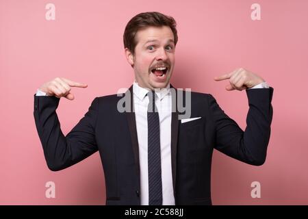Man proud of himself pointing on his chest over pink background. I am the best concept. Stock Photo