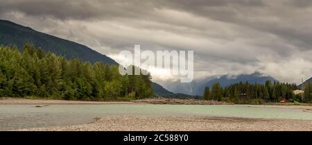 Flat, glacial blue back channel on the Skeena River at Gravel Yard Point, Terrace, British Columbia, Canada Stock Photo