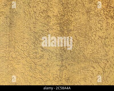 The texture of the plaster is bark beetle on the wall. Seamless yellow texture. Stock Photo