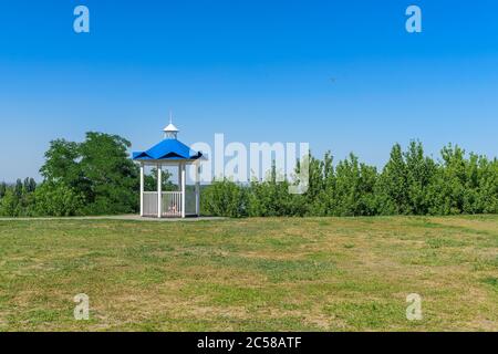 Romantic rotunda on the grass summer sunny day, clear blue sky Stock Photo