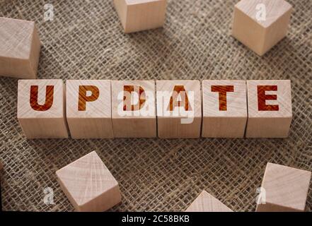 Update word on a wooden cubes on burlap canvas background. Business technologies manufacturing concept Stock Photo