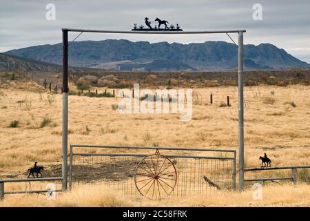 Ranch gate at Chihuahuan Desert near Presidio, Texas, USA with Sierra Grande massif across Rio Grande in Mexico in distance, winter Stock Photo