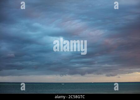 Colorful storm clouds gather over the Caribbean Sea. This warm, tropical region, full of idyllic islands, receives seasonal storms. Stock Photo