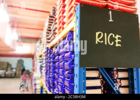 Rice signage at the aisle of supermarket with defocused merchandise on shelf Stock Photo